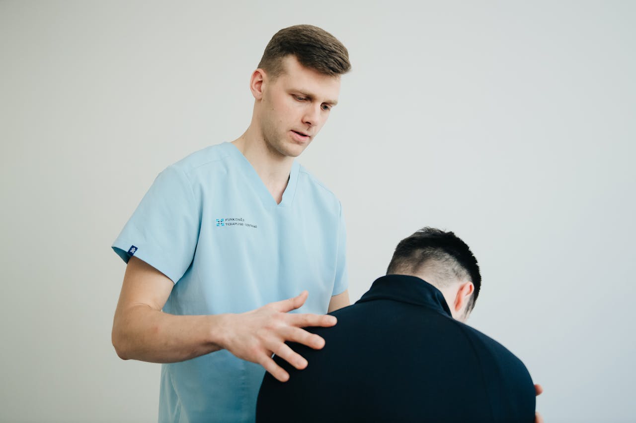 A physiotherapist assessing a patients posture indoors, showing support and expertise.